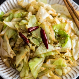 Infuse the oil with aromatics and then toss at a high heat, this adds a smoky flavor to the sweet fried cabbage and makes a quick and delicious side dish.