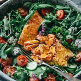 Flaked salmon on arugula with tomato and cucumber