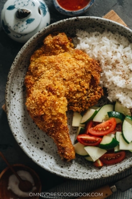 Crispy baked chicken leg served with rice and salad