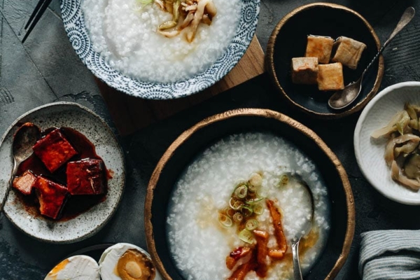 Plain congee topped with pickles, sesame oil and green onion