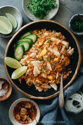 Crab fried rice with lime wedges and cucumber