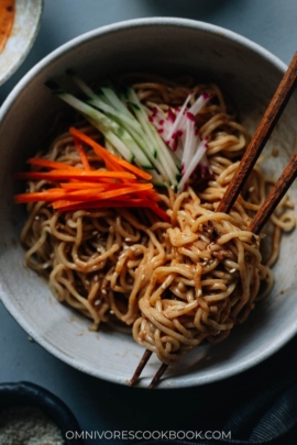 Chinese noodles in a bowl with sesame sauce and vegetables