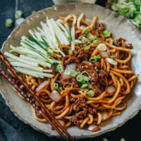 A classic Beijing dish, Zha Jiang Mian features ground pork and onion cooked in a rich savory brown sauce with a hint of sweetness, tossed with noodles and then served with crunchy cucumber. It takes no time to prepare, is easy to cook, and can be prepared ahead of time. It’s a perfect one-bowl dish for hot days and is great for meal prep as well.