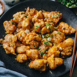 Homemade orange chicken garnished with green onion